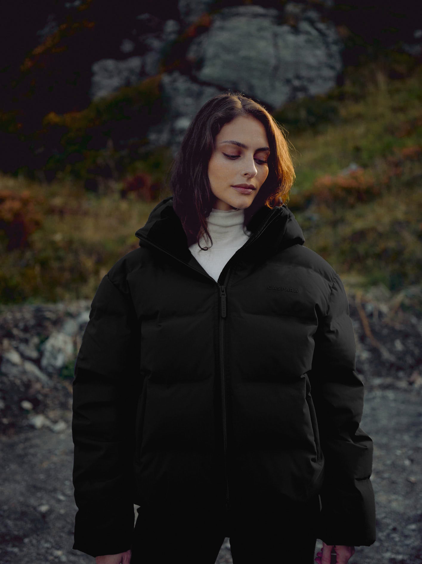 Woman wearing a black CASPARA Aurora puffer jacket outdoors.
